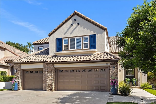 mediterranean / spanish-style home with a tiled roof, stone siding, concrete driveway, and stucco siding