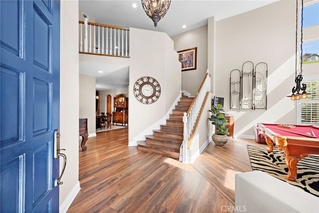 entrance foyer with dark hardwood / wood-style flooring, a high ceiling, billiards, and plenty of natural light