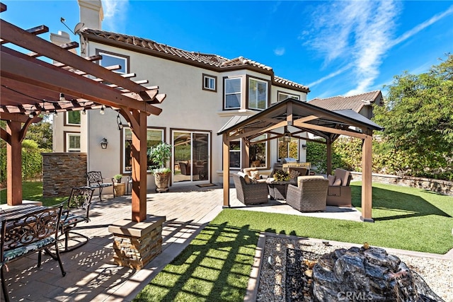 back of house featuring a yard, a patio, an outdoor living space with a fire pit, a pergola, and a gazebo