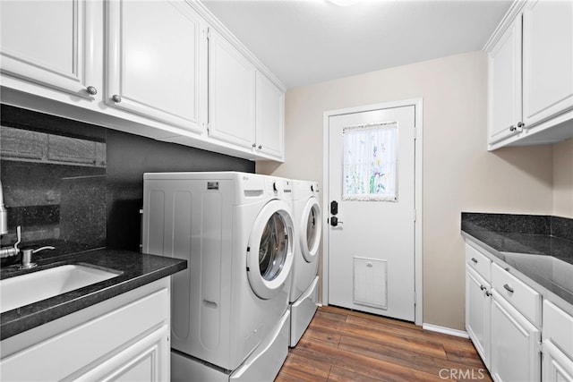 clothes washing area featuring cabinets, sink, separate washer and dryer, and dark hardwood / wood-style floors