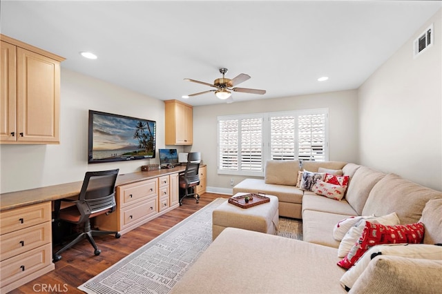 office area featuring built in desk, ceiling fan, and dark hardwood / wood-style flooring