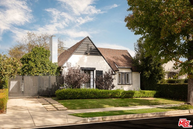 tudor-style house featuring a front lawn