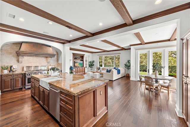 kitchen featuring custom exhaust hood, stainless steel appliances, a kitchen island with sink, sink, and dark hardwood / wood-style floors