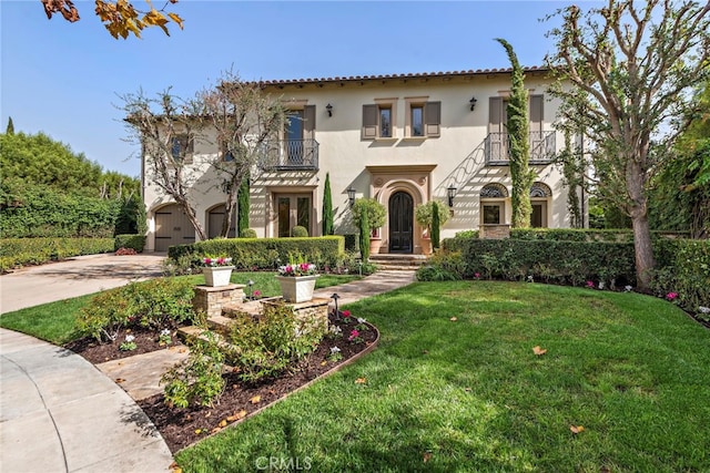 mediterranean / spanish-style house with a balcony, a front yard, and a garage