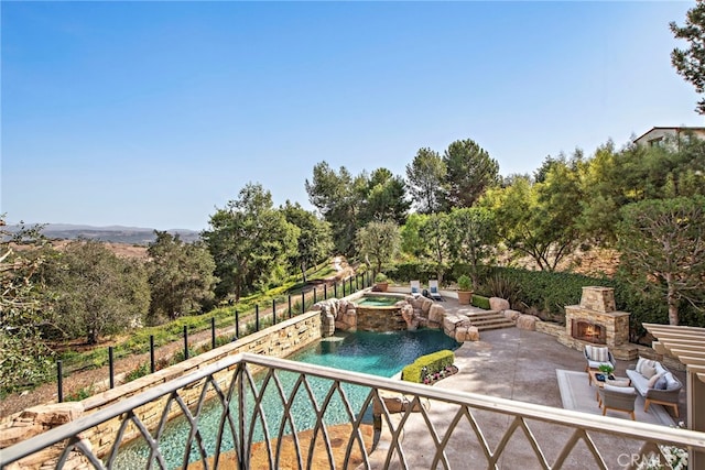 view of swimming pool with an outdoor stone fireplace, a patio area, and an in ground hot tub