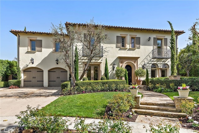 mediterranean / spanish-style home with a garage and a front lawn