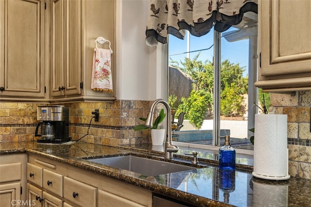 kitchen with light brown cabinets, decorative backsplash, sink, and dark stone counters