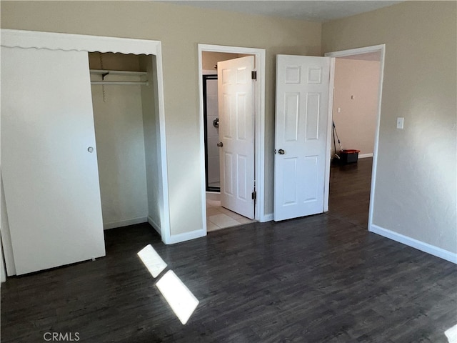 unfurnished bedroom featuring a closet and dark wood-type flooring