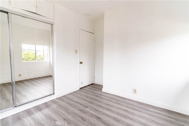 unfurnished bedroom featuring light hardwood / wood-style flooring and a closet