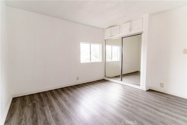 unfurnished bedroom with hardwood / wood-style flooring and a closet