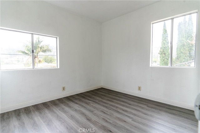 unfurnished room featuring a wealth of natural light and hardwood / wood-style floors