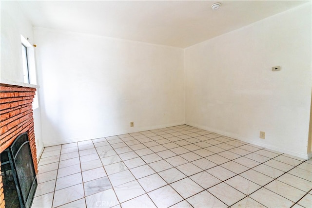 unfurnished living room featuring a brick fireplace and light tile patterned floors