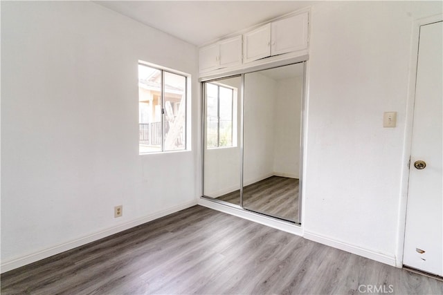 unfurnished bedroom featuring a closet and light wood-type flooring