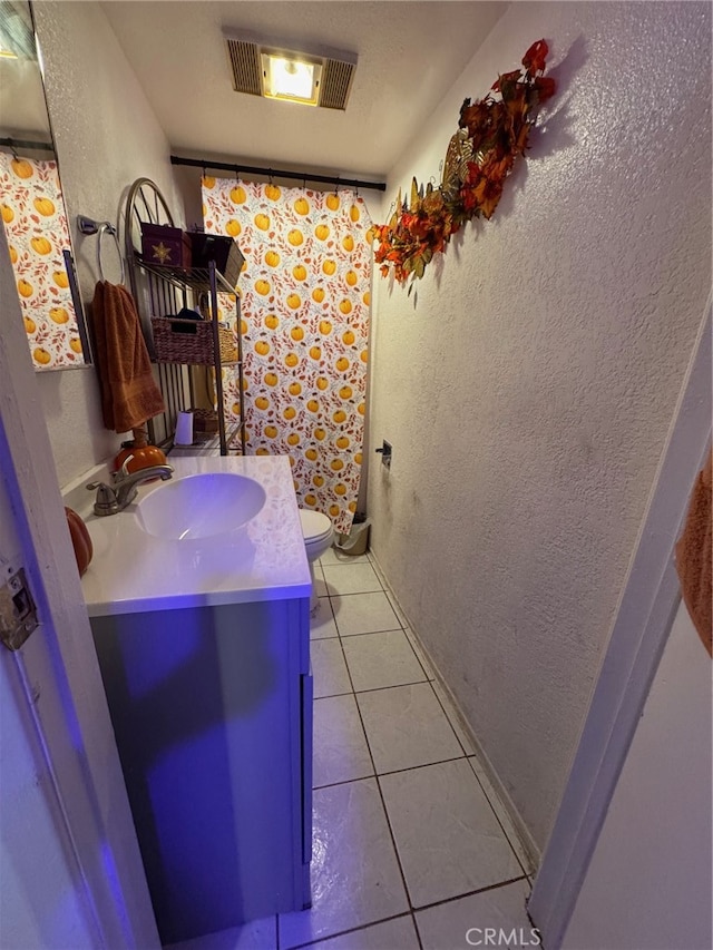 bathroom featuring vanity, toilet, and tile patterned flooring