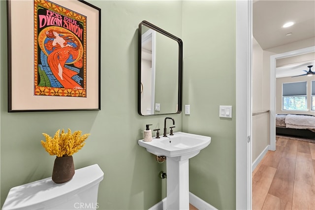 bathroom with hardwood / wood-style floors, toilet, and ceiling fan