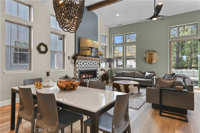 dining room featuring beamed ceiling, high vaulted ceiling, light hardwood / wood-style floors, and ceiling fan