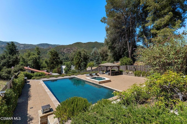 view of swimming pool featuring a gazebo, a mountain view, and an in ground hot tub