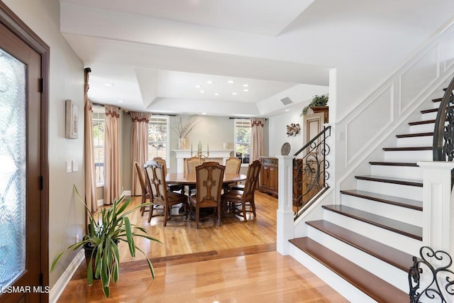 dining area featuring light hardwood / wood-style floors and a raised ceiling