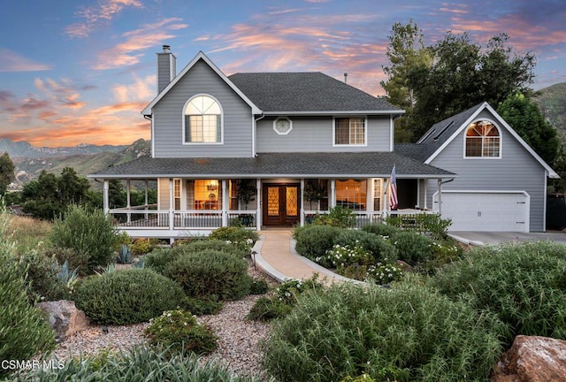 view of front facade featuring a mountain view, a garage, and covered porch