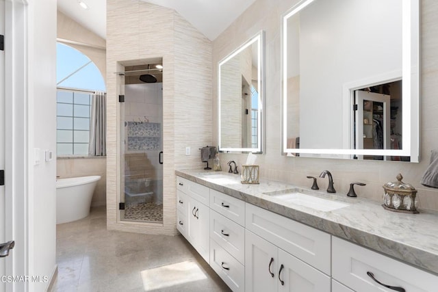 bathroom featuring tile walls, vanity, vaulted ceiling, and shower with separate bathtub