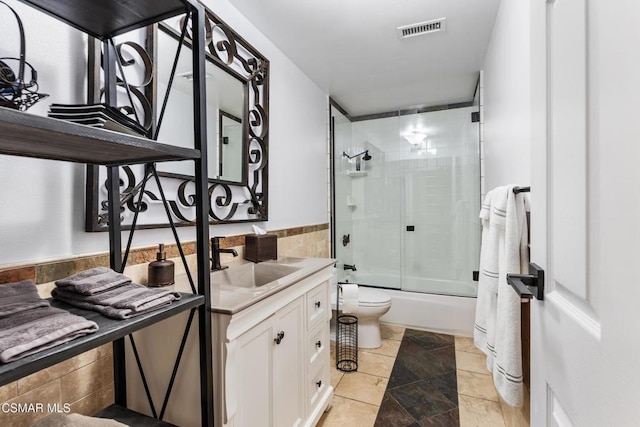 full bathroom featuring vanity, toilet, and enclosed tub / shower combo