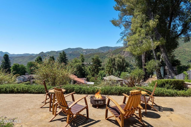 view of patio / terrace with a mountain view and an outdoor fire pit