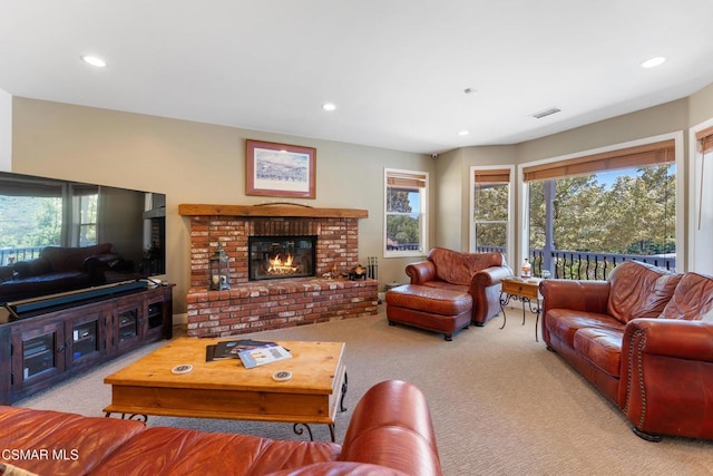 carpeted living room with a brick fireplace