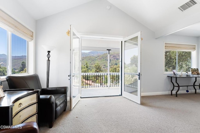 sitting room with a mountain view, french doors, carpet flooring, and vaulted ceiling