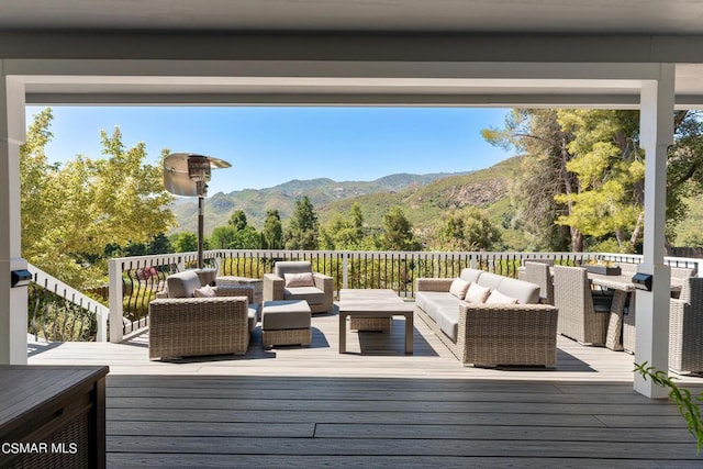 wooden terrace featuring a mountain view and an outdoor hangout area