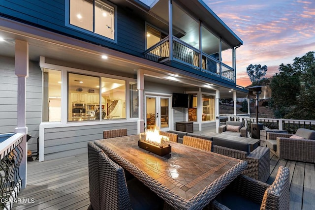 deck at dusk featuring a fire pit