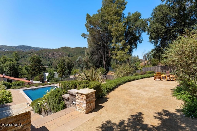 view of swimming pool with a mountain view and a patio area