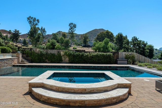 view of swimming pool with a mountain view, an in ground hot tub, and a patio