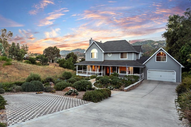 view of front of home featuring covered porch, a mountain view, and a garage