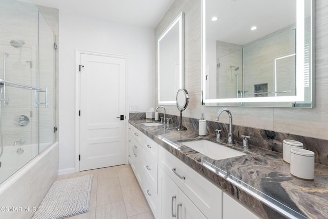 bathroom with tile patterned floors, shower / bath combination with glass door, and vanity