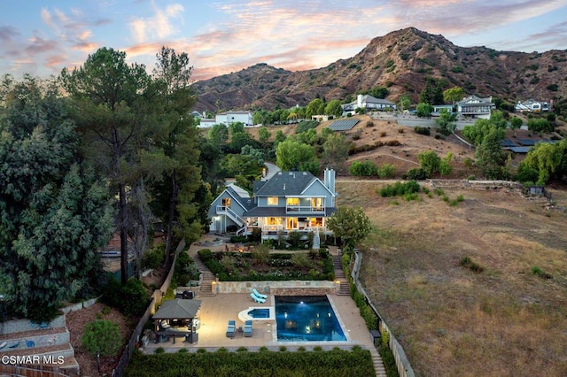 aerial view at dusk featuring a mountain view