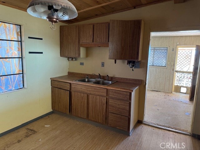 kitchen featuring sink, wooden ceiling, light wood-type flooring, and vaulted ceiling