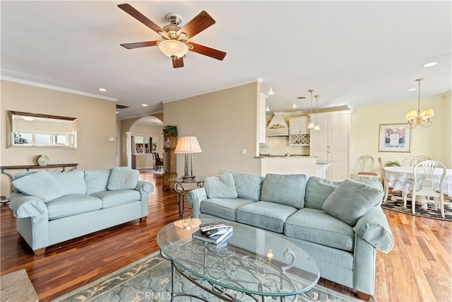 living room featuring hardwood / wood-style floors, crown molding, and ceiling fan with notable chandelier