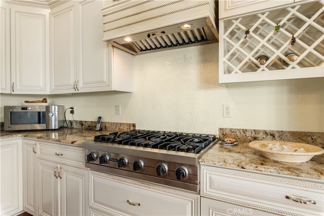 kitchen featuring premium range hood, light stone countertops, and stainless steel appliances