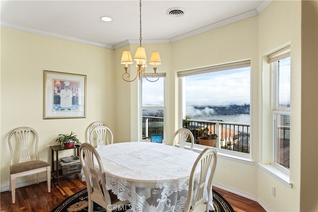 dining room with crown molding, a chandelier, and dark wood-type flooring