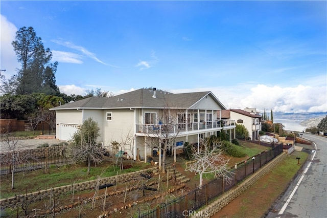 back of house featuring a balcony and a garage