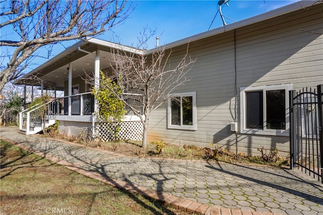 view of side of home with covered porch