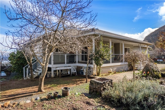 back of property featuring covered porch