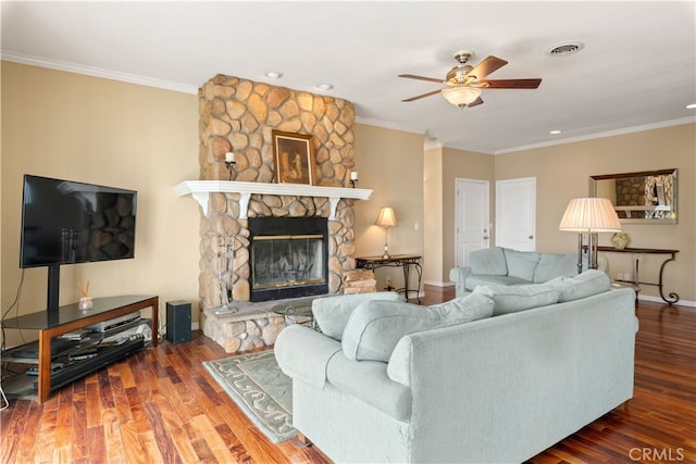 living room featuring ornamental molding, hardwood / wood-style flooring, and a fireplace