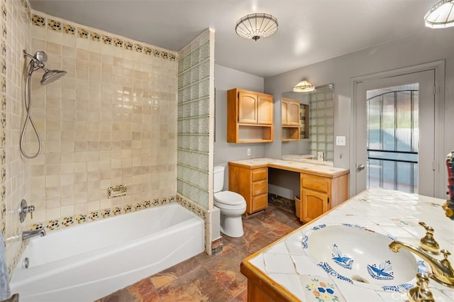 full bathroom with vanity, tiled shower / bath combo, and toilet