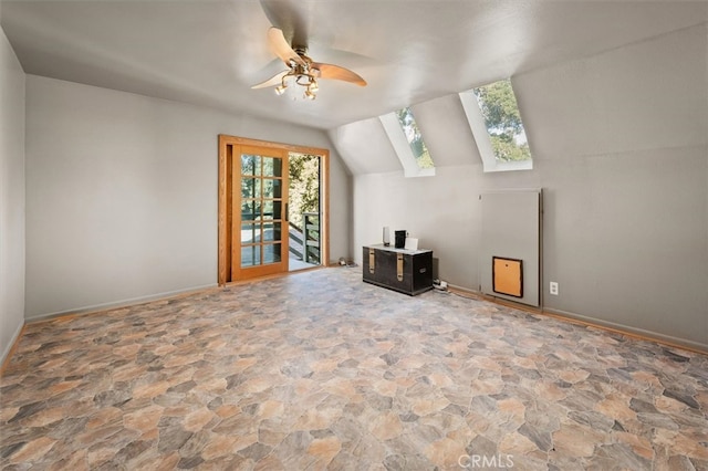 additional living space featuring vaulted ceiling with skylight and ceiling fan