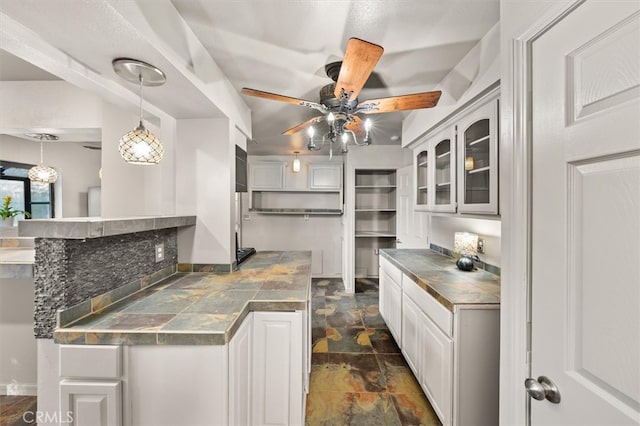 kitchen with kitchen peninsula, white cabinetry, ceiling fan, and pendant lighting