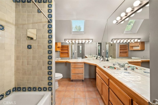 full bathroom with toilet, tile patterned flooring, tiled shower / bath combo, vanity, and a skylight