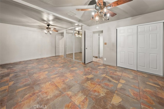 unfurnished bedroom with ceiling fan and two closets