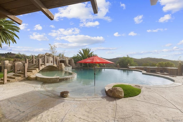 view of swimming pool with an in ground hot tub