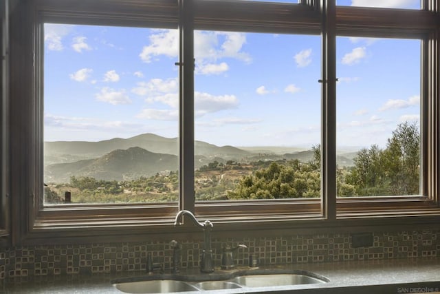 details with a mountain view, decorative backsplash, and sink